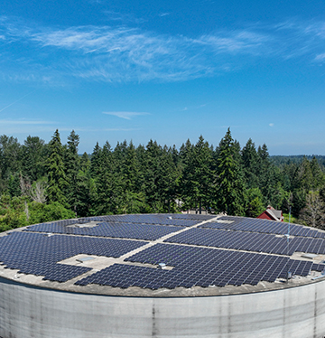 Aerial view of solar panels covering round concrete structure at Bonney Lake