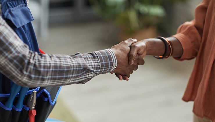 woman shaking hands with handyman