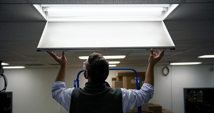 Business owner installing light fixture