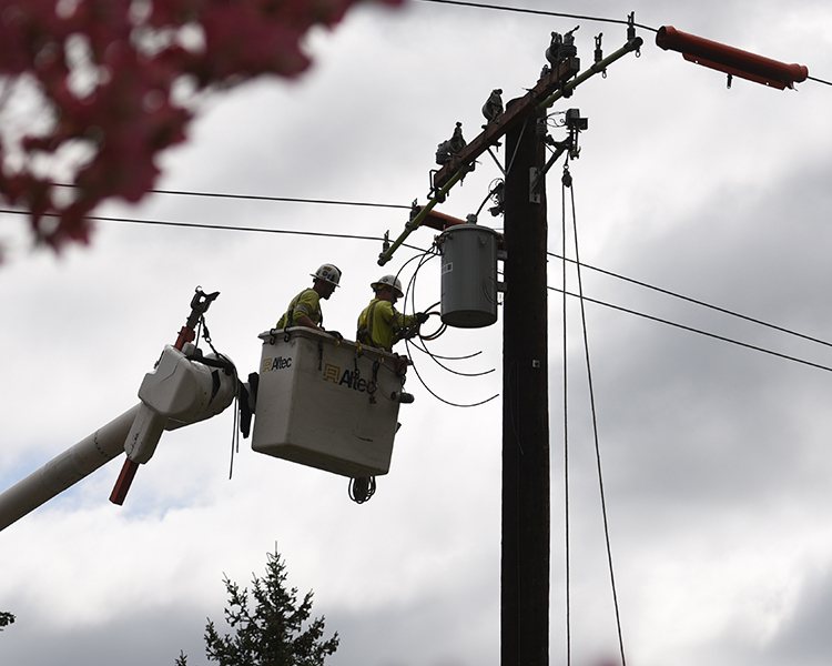 Crews work to upgrade overhead electric wire and utility poles