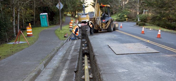 Construction workers covering new natural gas pipe