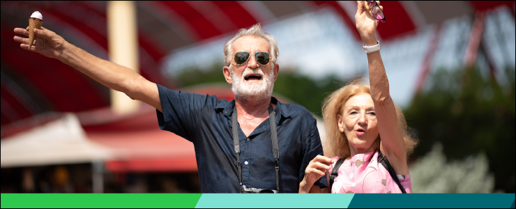 A senior couple waving ice cream cones in the air