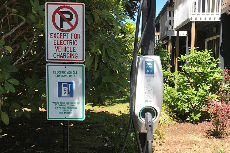An EV charging station in a shaded area of a housing complex.