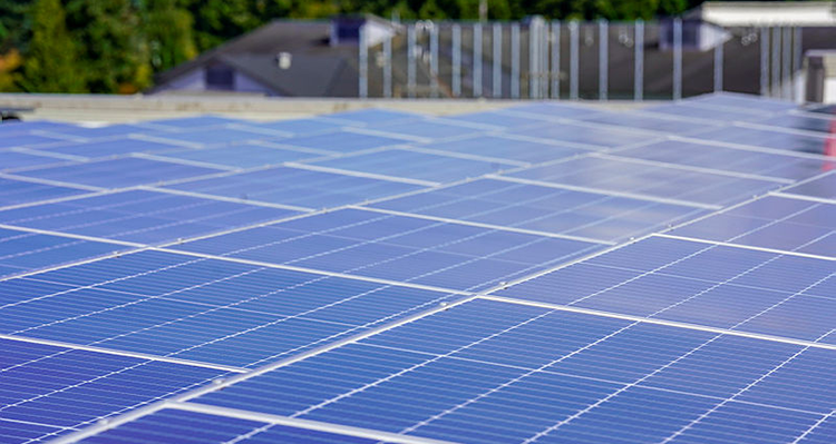 Solar panels installed on a rooftop reflecting the blue sky