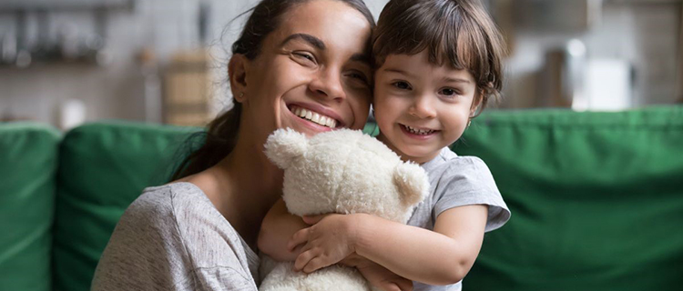 Adult with child holding a teddy bear