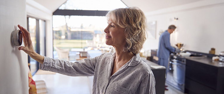 스마트 온도 조절기를 조정하는 사람